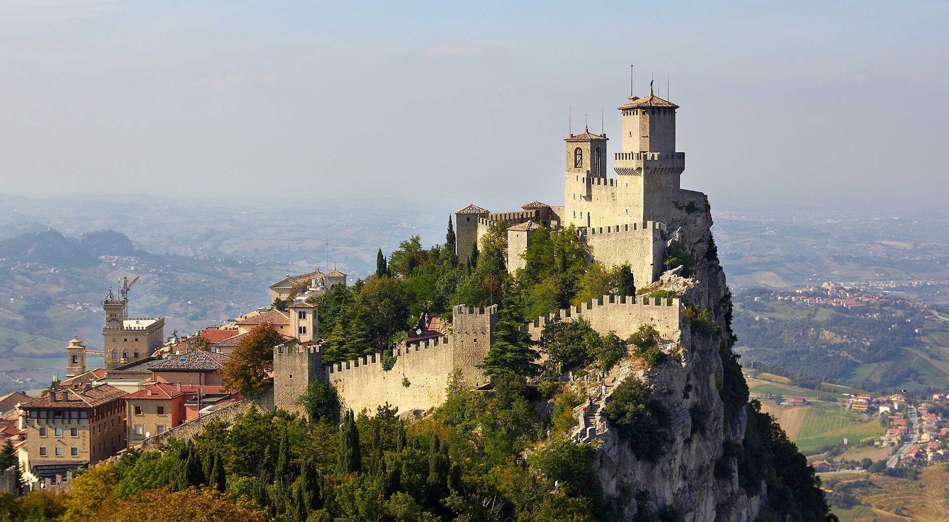 The Guaita Tower — first of San Marino's Three Towers — rising above Monte Titano at dusk, visible from the closing holes at Rimini Verucchio Golf Club.